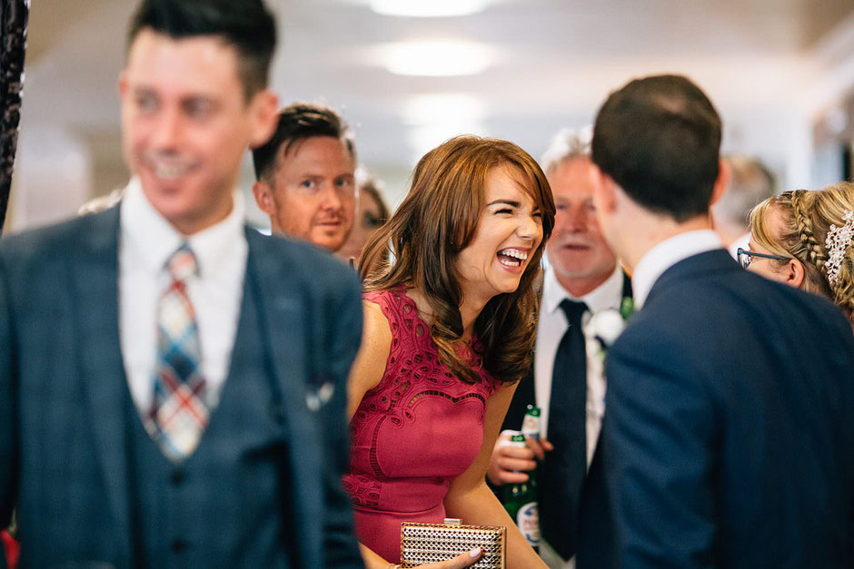 candid photograph of a wedding guest laughing