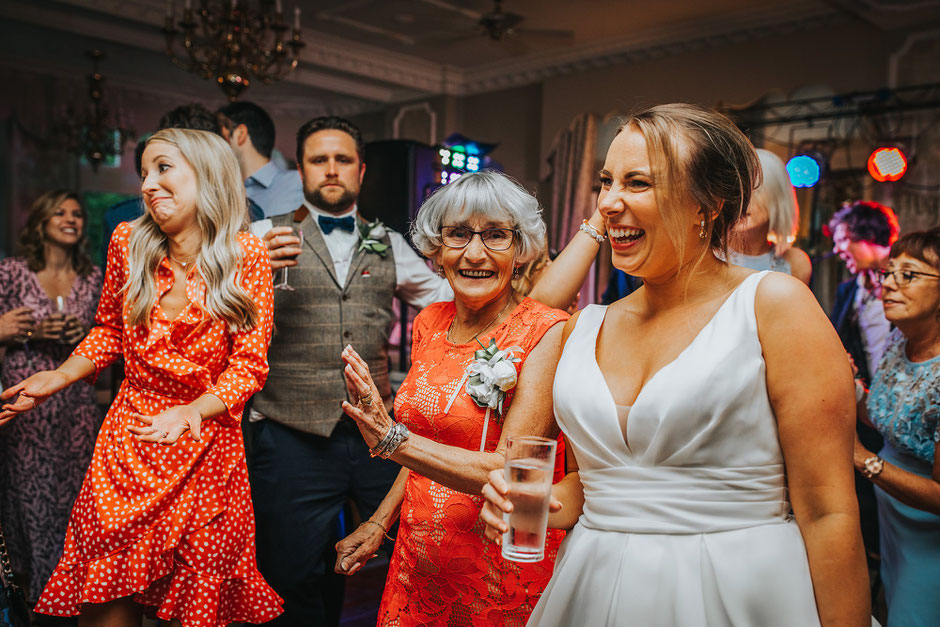 lots of people on the dance floor at a wedding