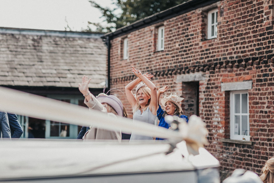 candid shots of guests at meols hall waving at a drone