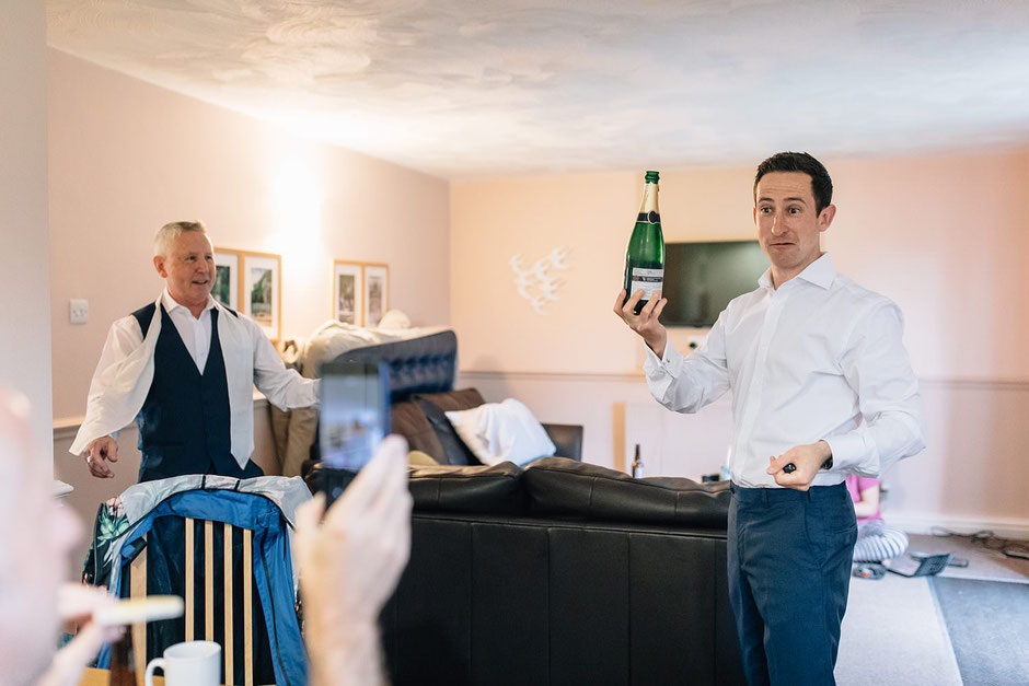 a photograph of a man holding up a bottle of champagne