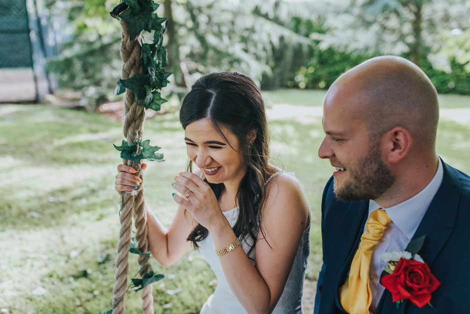 bride laughing whilst on a swing at soughton hall