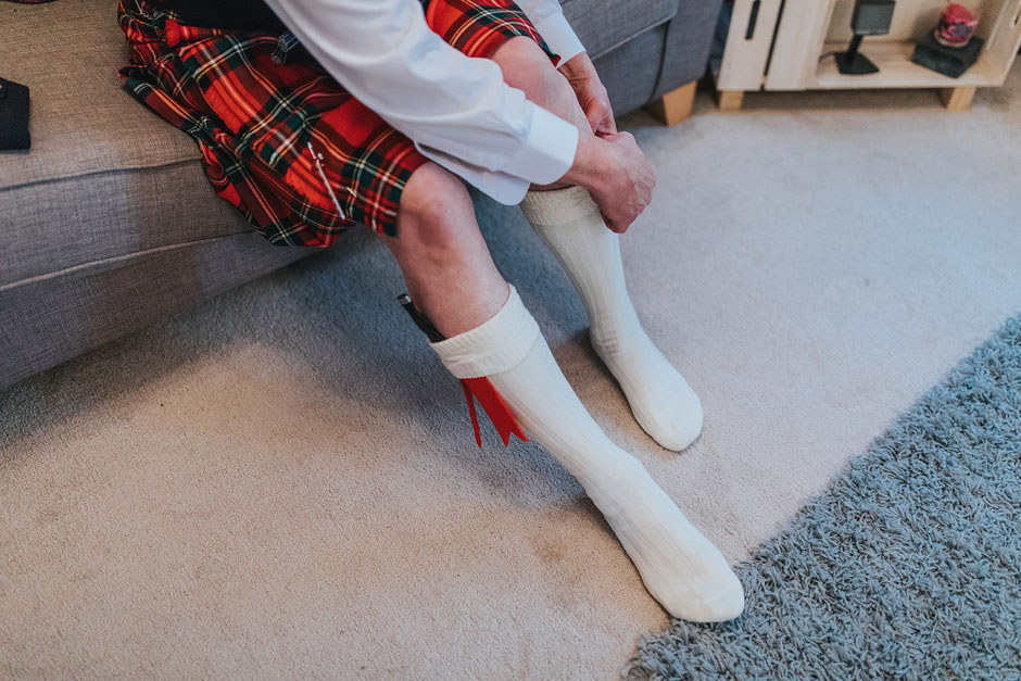 Detail shot of father of the bride getting dressed into his Scottish dress