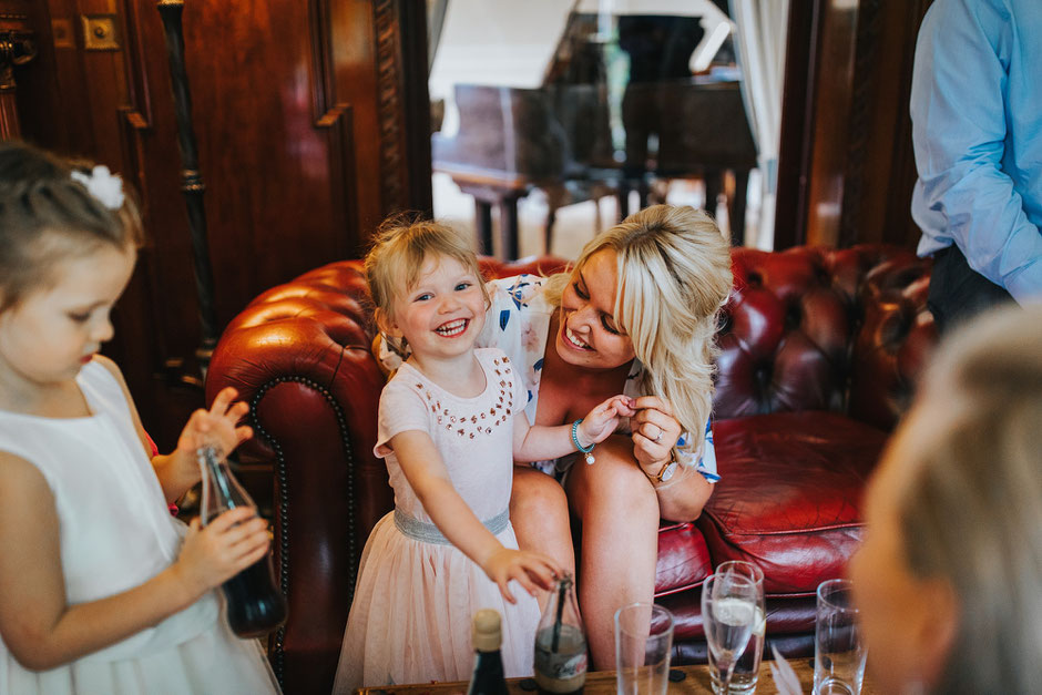 candid photograph of a little girl laughing with her Mum
