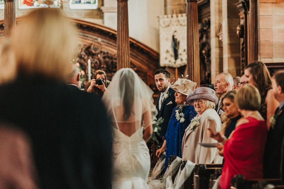 a photograph of the grooms face as he sees his bride for the first time