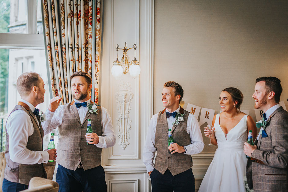 candid photograph of wedding guests holding beers and chatting