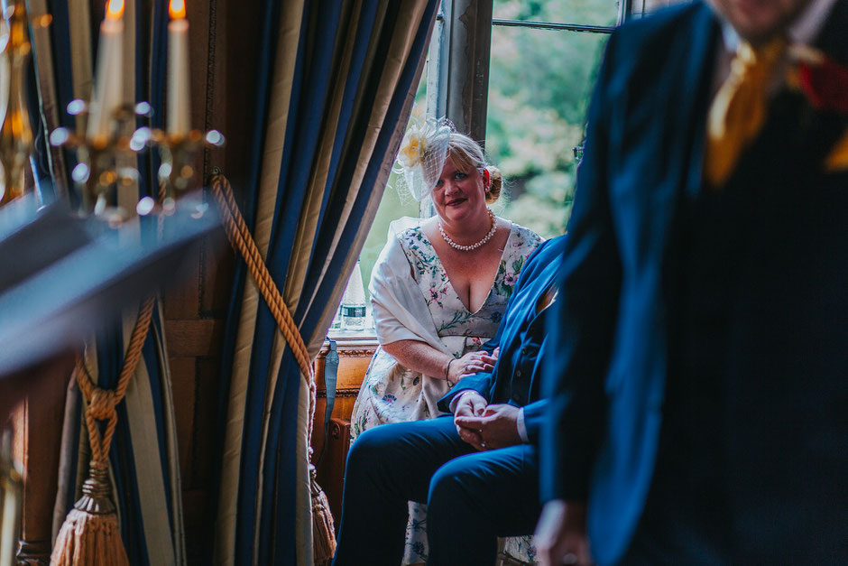 Photograph of the grooms step Mum smiling at him during the wedding ceremony at Soughton Hall