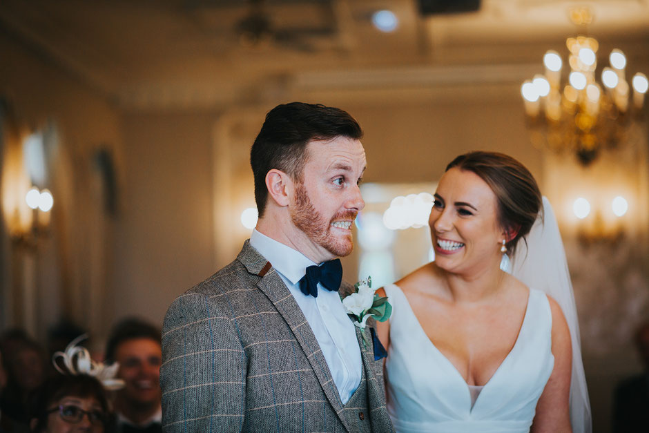an excited groom pulling a funny face during his wedding ceremony