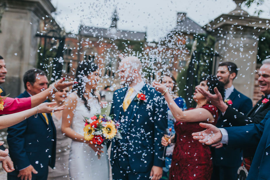 confetti throw with bride and groom covered by the confetti