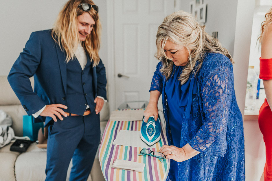 photograph of a lady in a blue dress ironing pocket squares