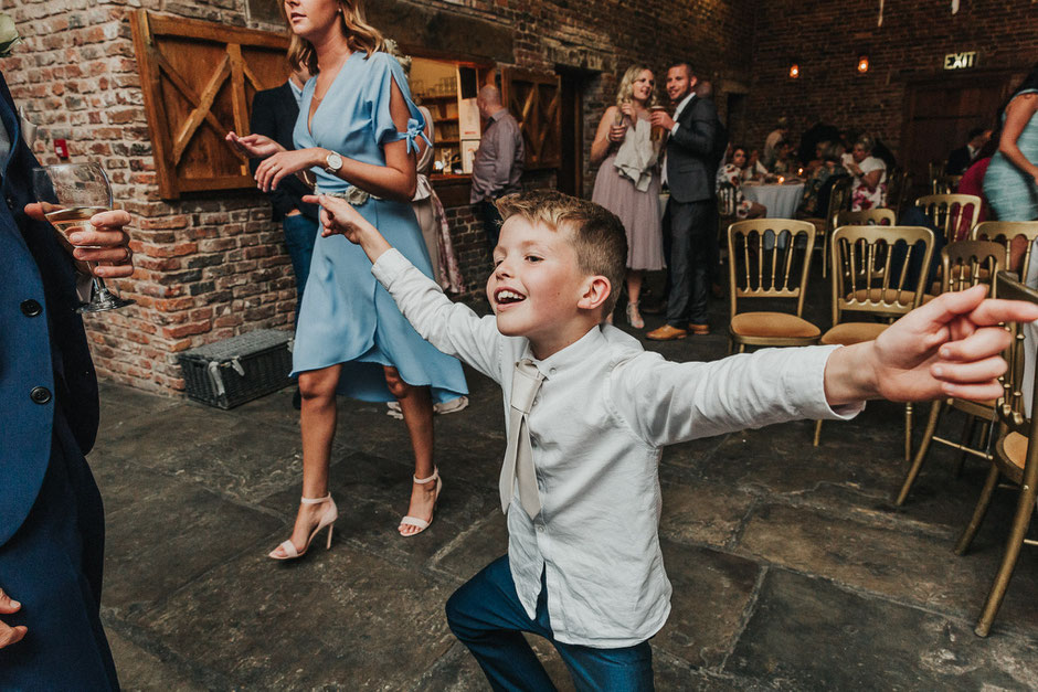 a little boy having fun with his arms out wide dancing to music