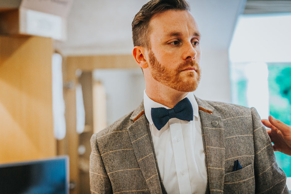 Groom in a tweed suit and bow tie on the morning of his Lake District wedding