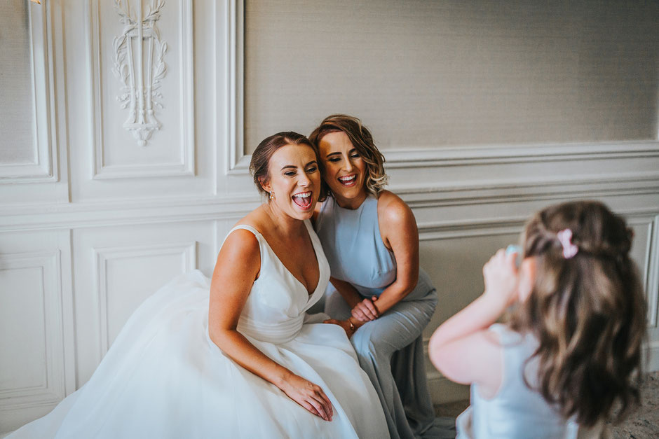 a bride and her bridesmaid posting for a polaroid photograph