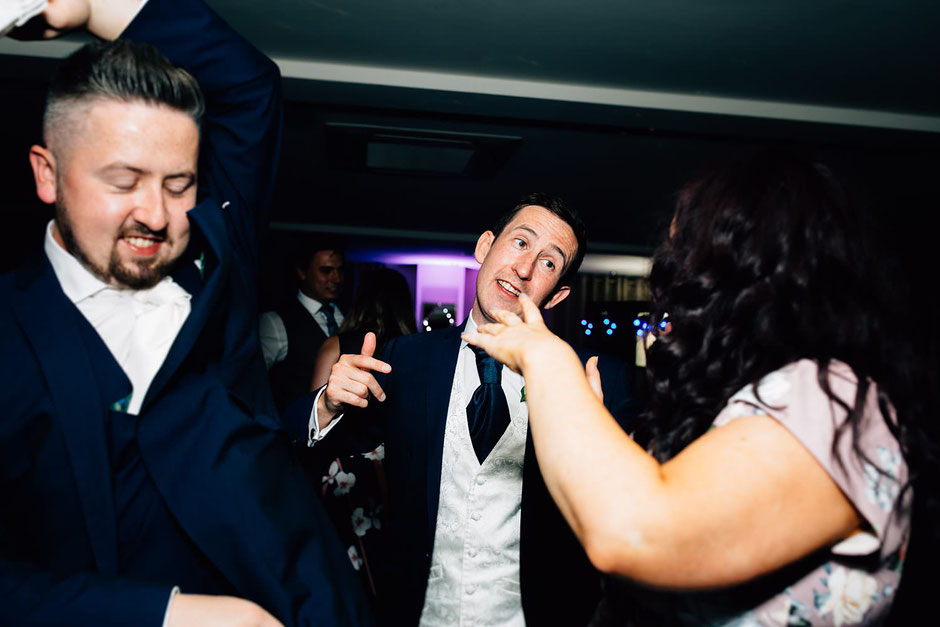 wedding guests on a dancefloor singing