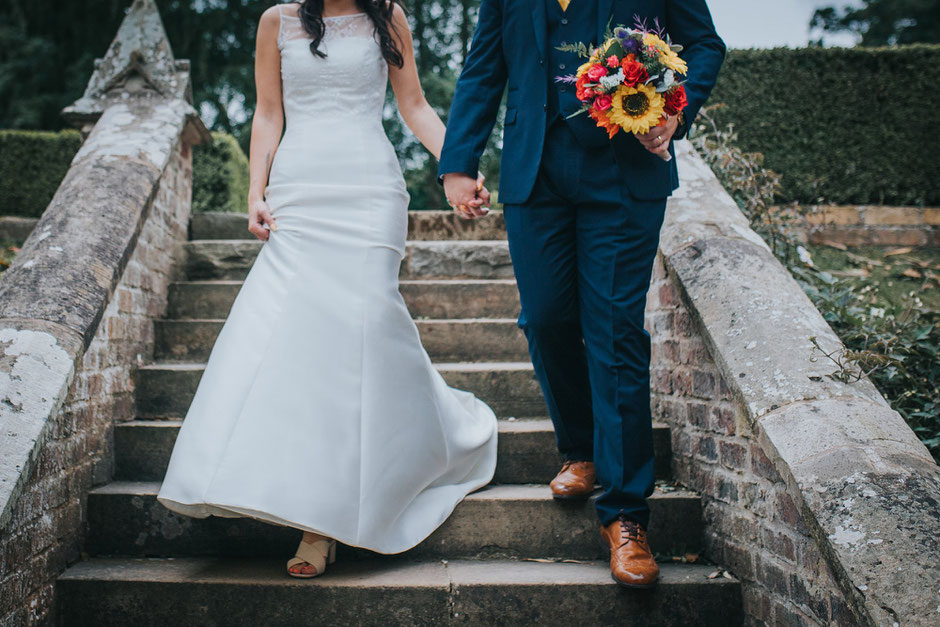 photograph of bride and grooms shoes as they walk down some steps