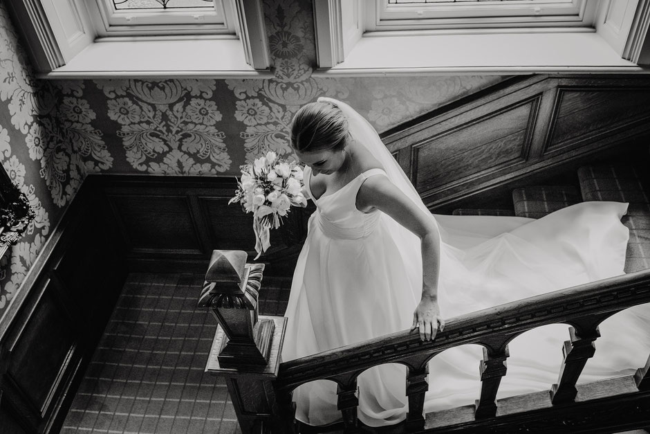 bride walking down the stairs towards the wedding ceremony at the merewood country house hotel