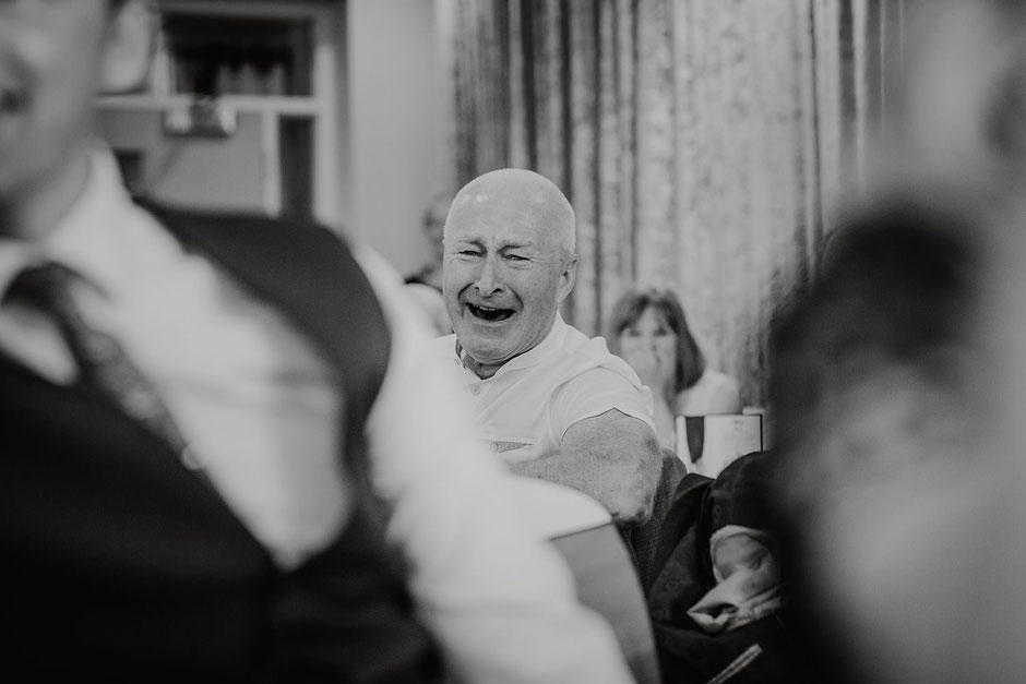 black and white photograph of a man laughing during wedding speeches at Ribby hall