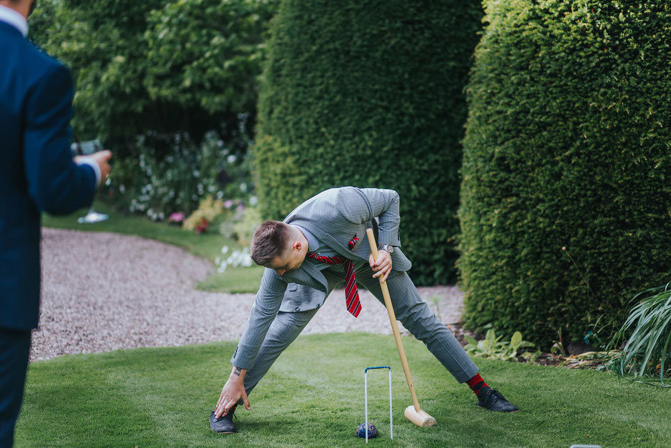 a wedding guest stretching before playing lawn games