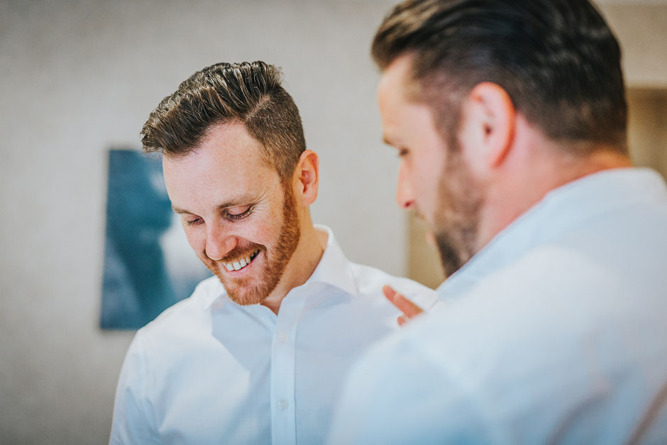 Candid photograph of a man smiling on his wedding day