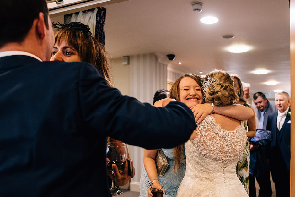 a bride being hugged by one of her guests