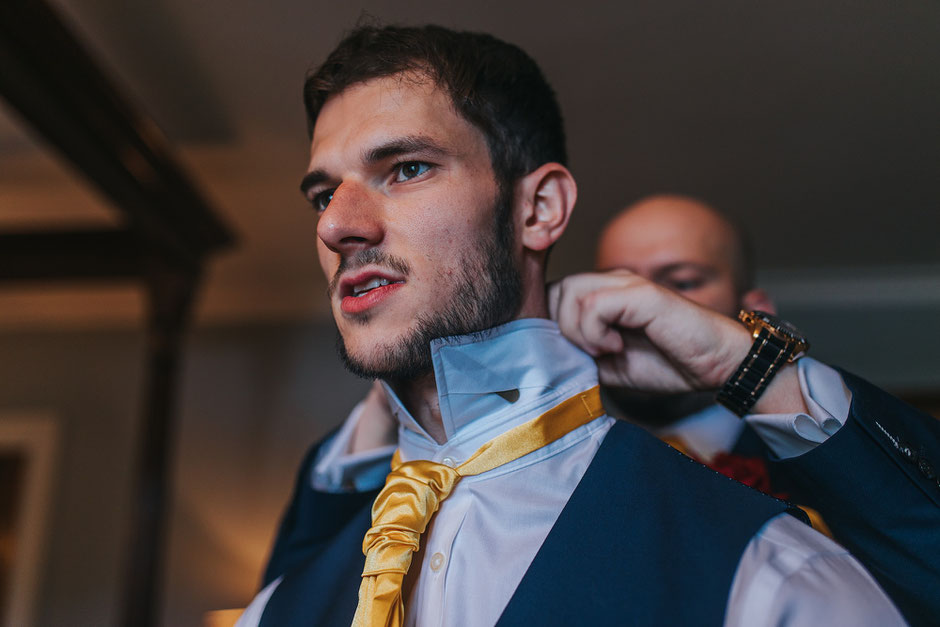 The best man at Soughton Hall being dressed by his brother