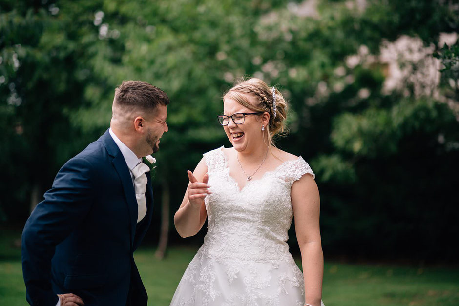 candid photograph of a bride and her bridesman laughing