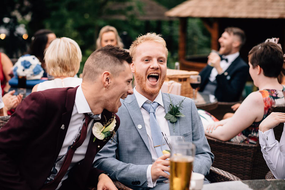 candid photograph of a guests dressed in a blue suit laughing