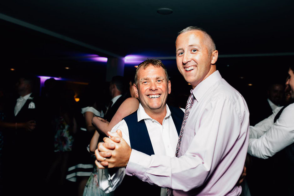 two men dancing during a wedding reception at ribby hall