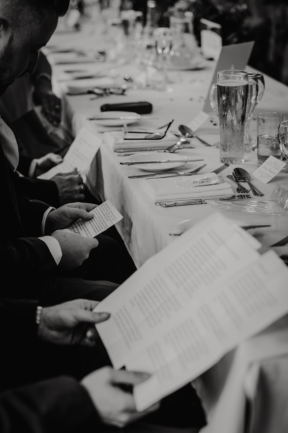 black and white photograph of three men holding speeches during a wedding breakfast