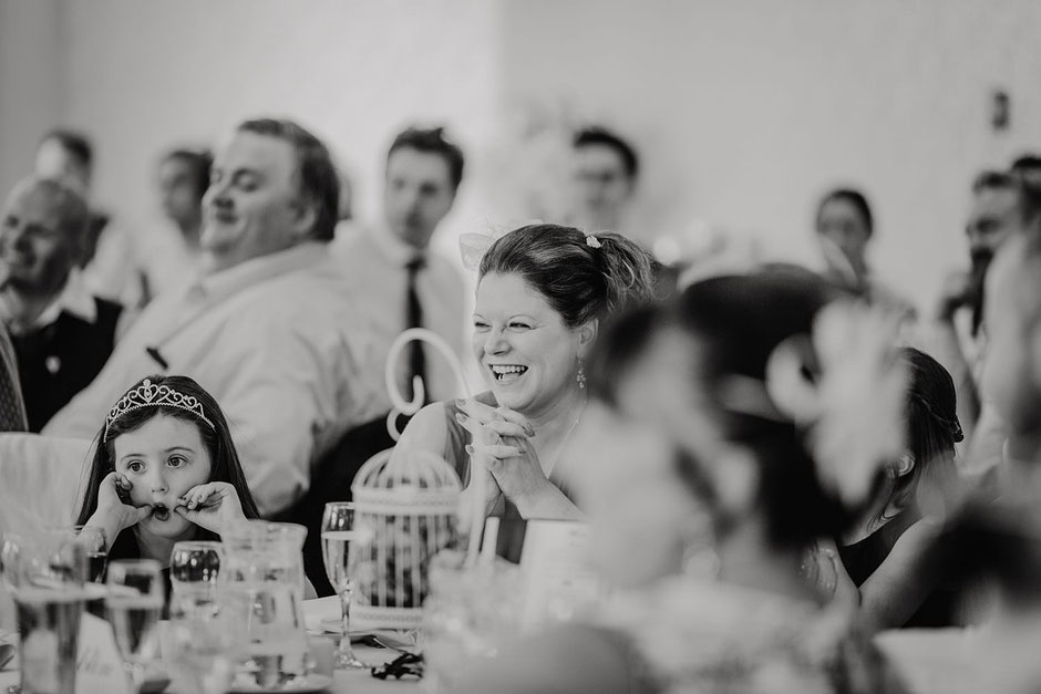 black and white photograph of a wedding guest laughing during speeches