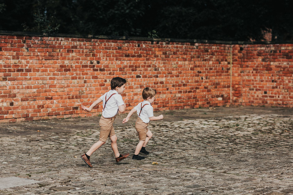 two little boys running around in the courtyard of meols hall