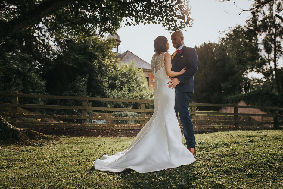 Bride and groom at sunset. Photograph showing the back of the brides dress in detail