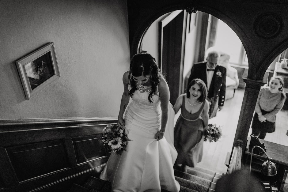 Bride & bridesmaids walking up the stairs at Soughton Hall