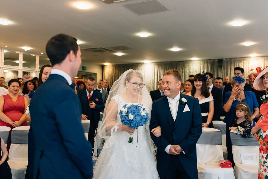 a bride walking down the aisle with a veil over her face