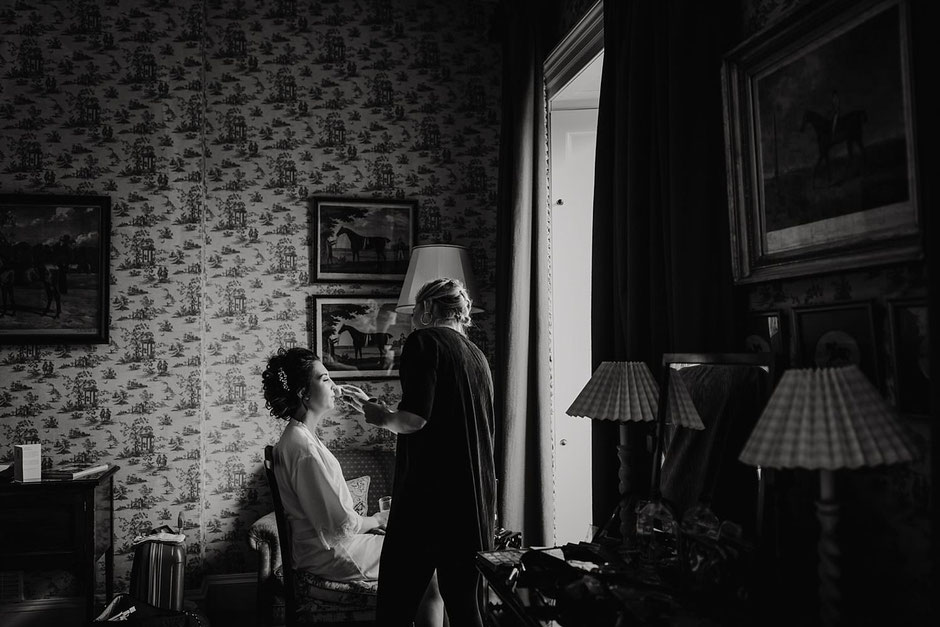bride having her make up done in window light in a room at Knowsley hall