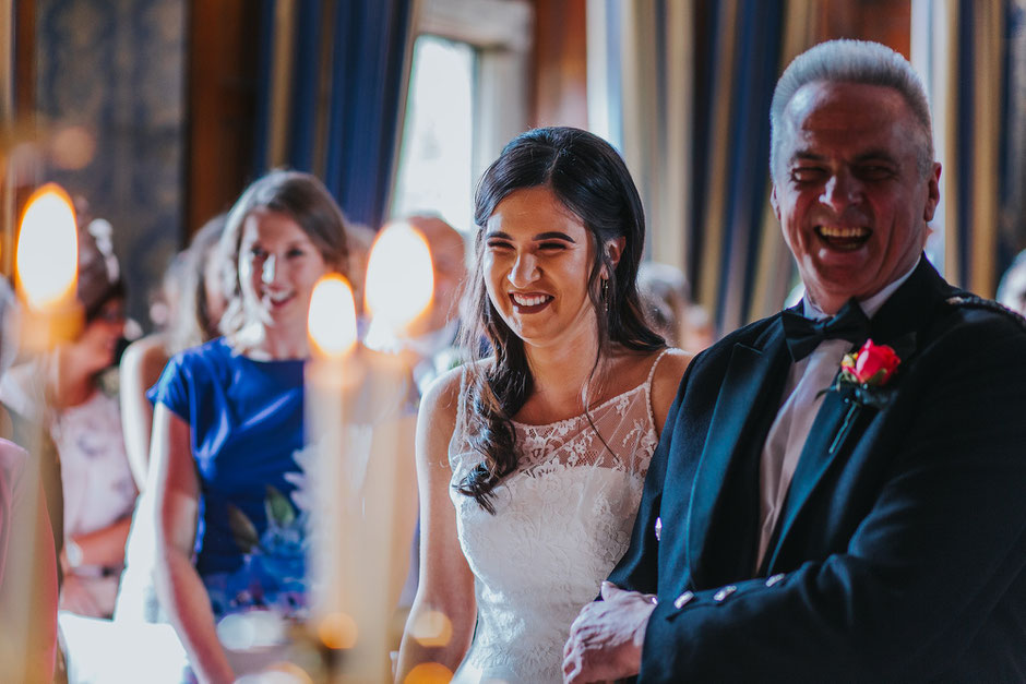 A bride looking really happy as she walks down the ailse