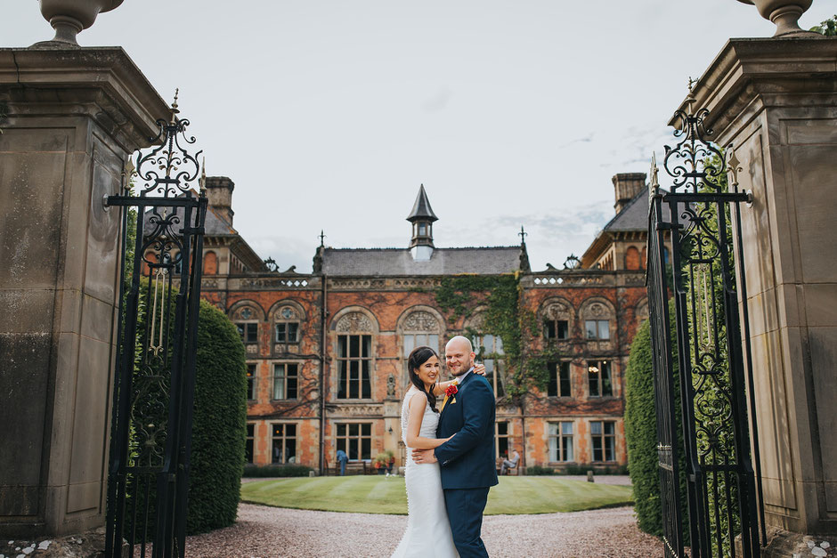 bride and groom posting in front of soughton hall
