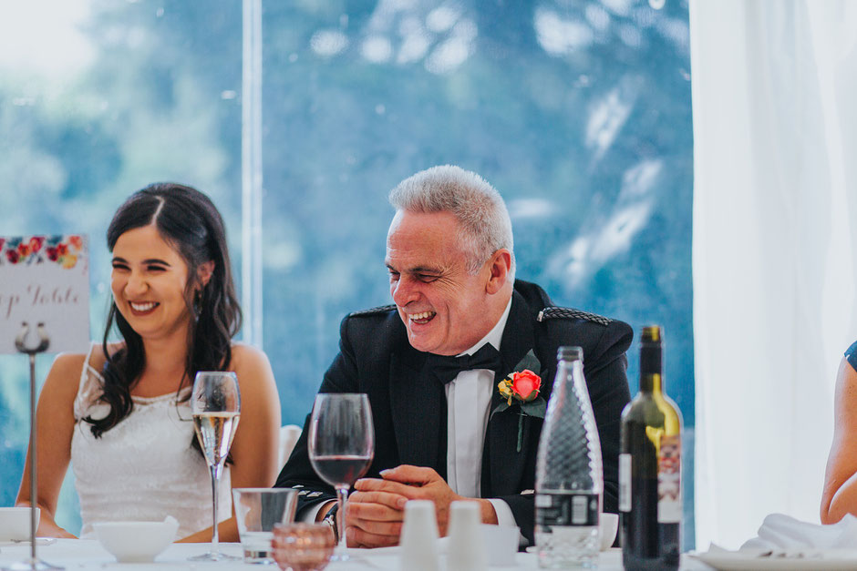 father of the bride laughing during wedding speeches