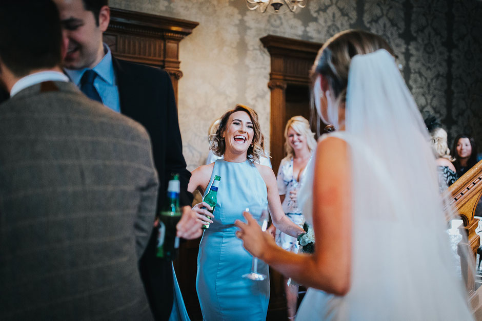 candid photo of a bridesmaid coming towards the bride to say congratulations
