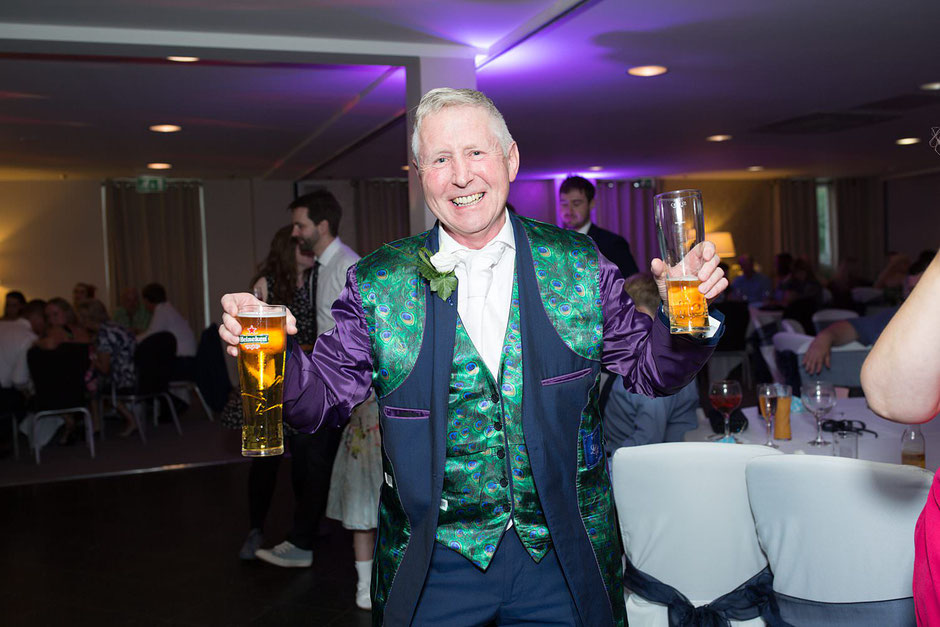wedding guest showing off his peacock feather covered suit