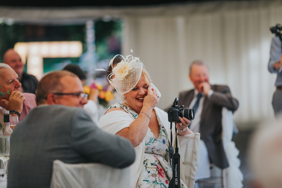 a wedding guest wiping tears away during wedding speeches