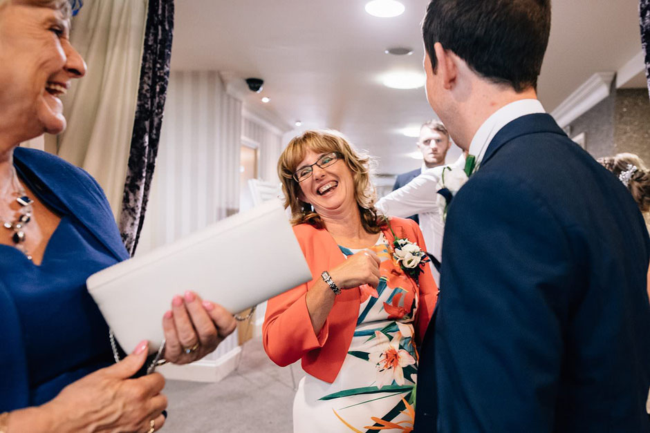 candid photograph of a woman laughing at a wedding