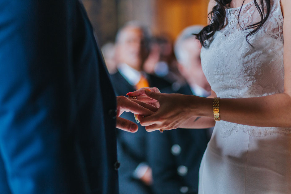Close up shot of a bride putting on her husbands ring during the wedding ceremony at soughton hall