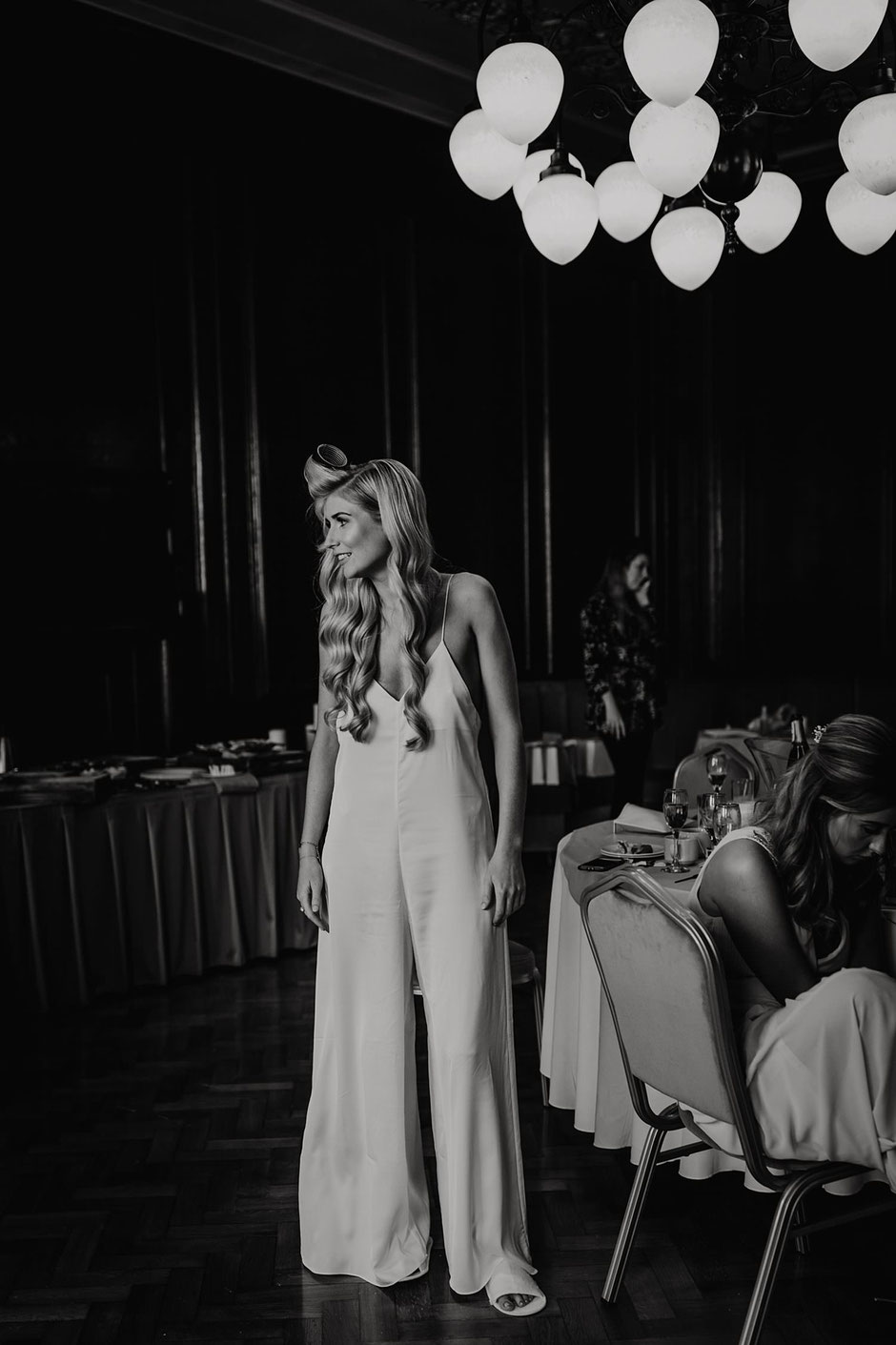 black and white photograph of a bride in an all in one pyjama suit
