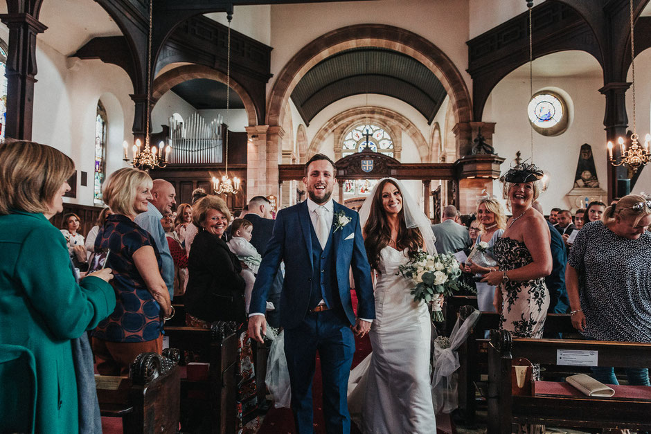 bride and groom leaving church after they are married
