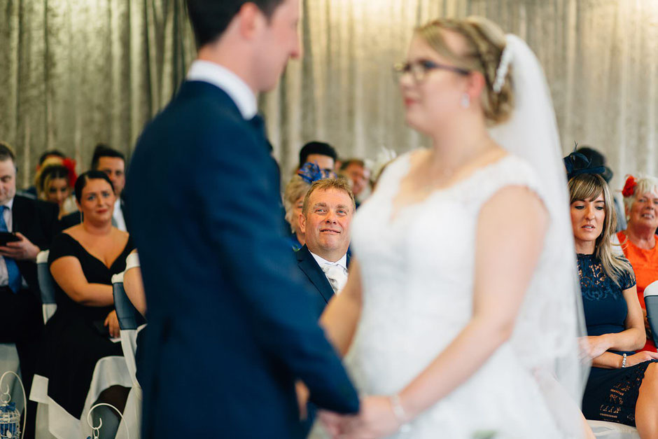 photograph of a proud dad watching as his daughter gets married