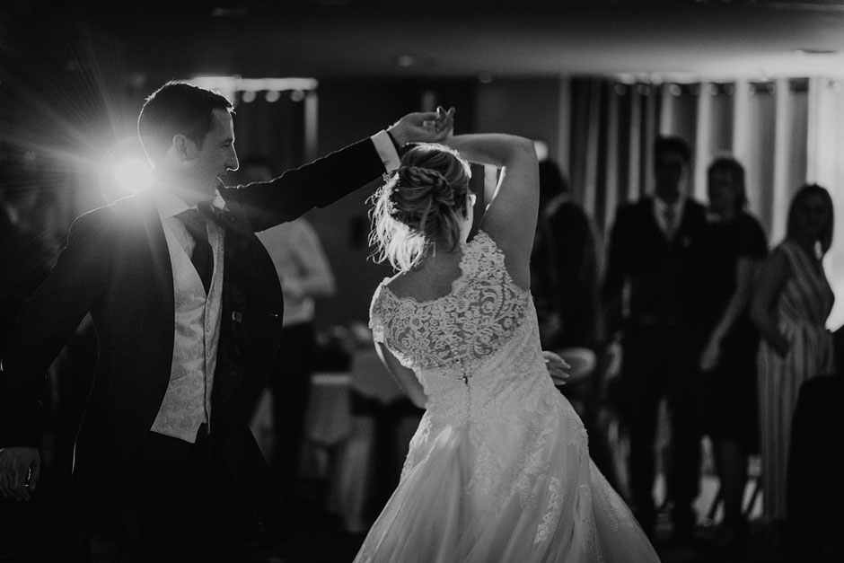 black and white photo of a groom spinning his bride