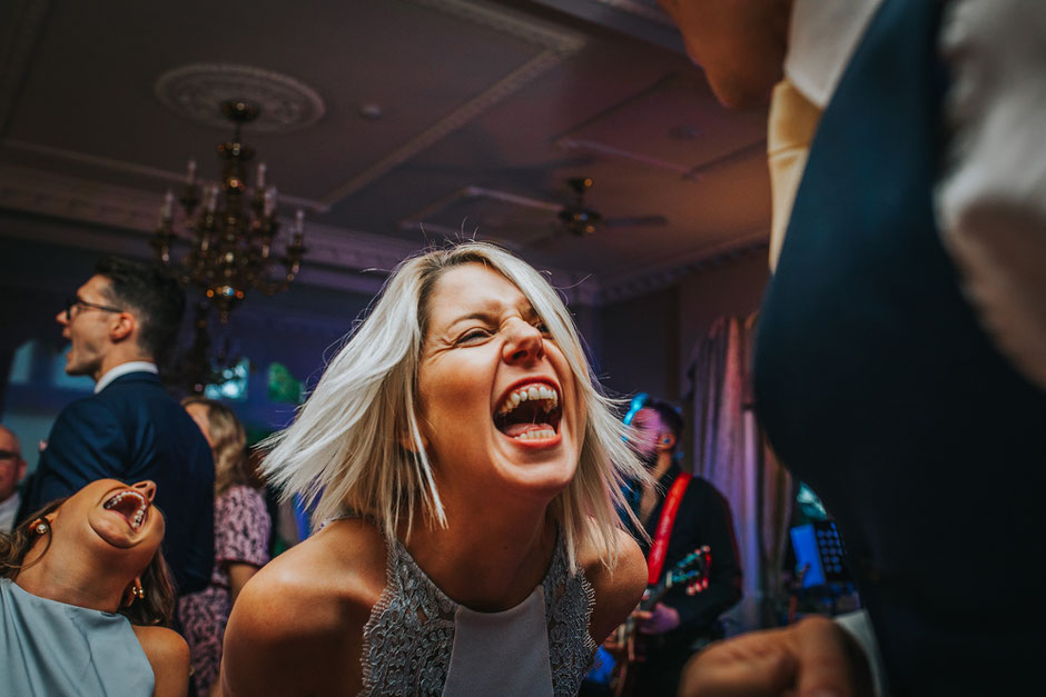 two women laughing at a wedding reception
