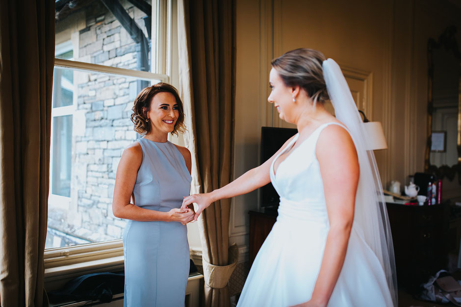 a moment between two sisters. One a bridesmaid and one the bride