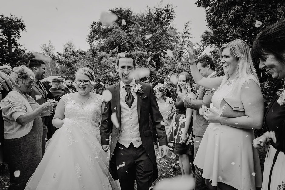 bride and groom walking through a confetti tunnel at ribby hall
