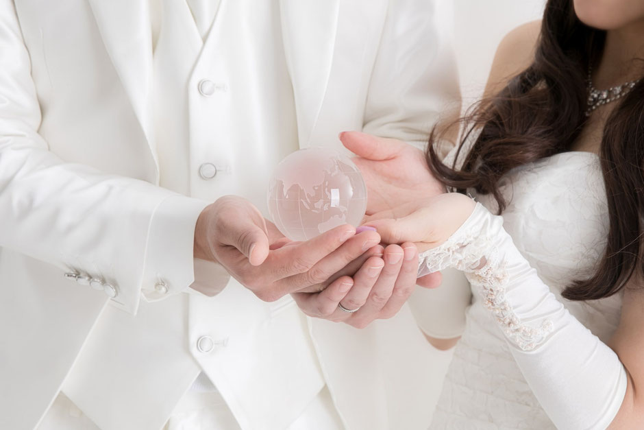 ガラスの地球儀を持つ結婚式のカップル